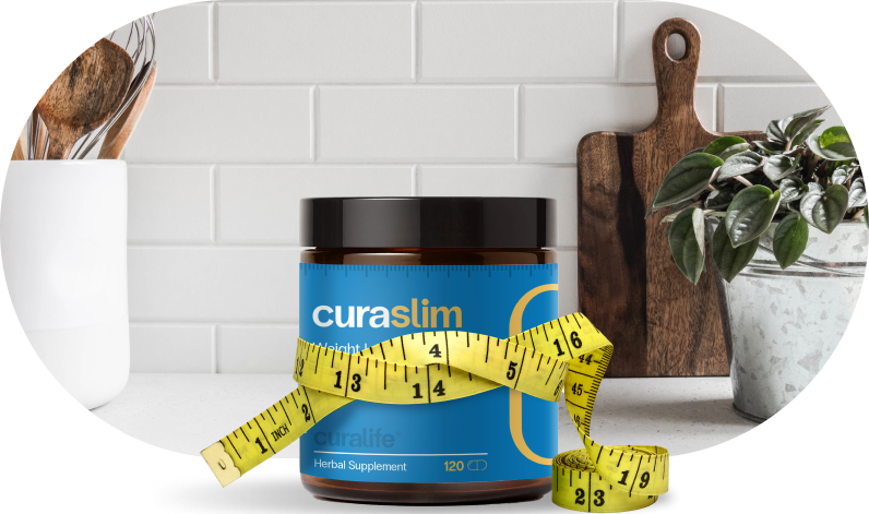 A bottle of CuraSlim weight loss supplement is sitting on a kitchen counter. A measuring tape is wrapped around the bottle. There is a wooden cutting board, a plant, and a whisk in the background.